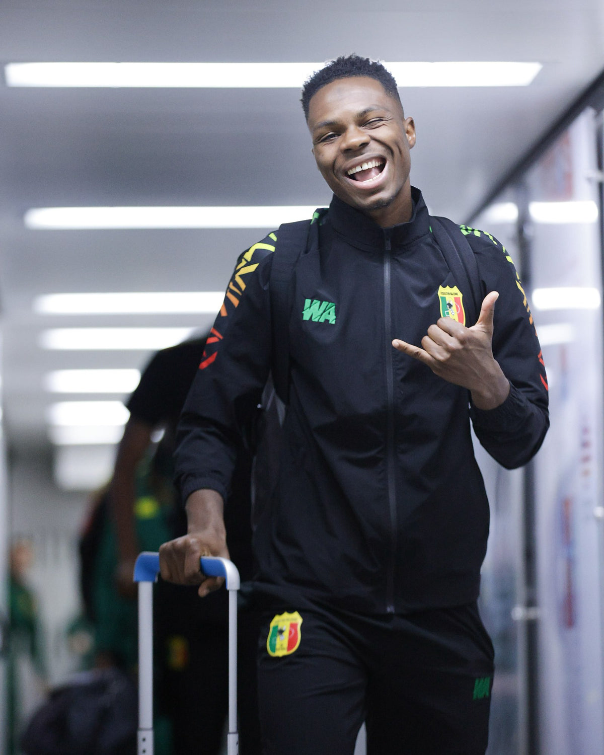 Joueur des Aigles du Mali en survêtement WA noir à l’aéroport